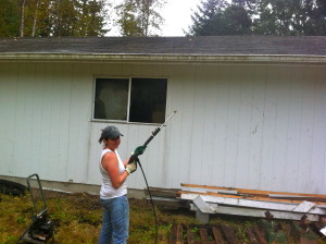 Sarah pressure spraying the garage gutters